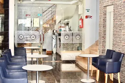 a restaurant with tables and chairs in a room at ZELLAKA hôtel & café in Khouribga