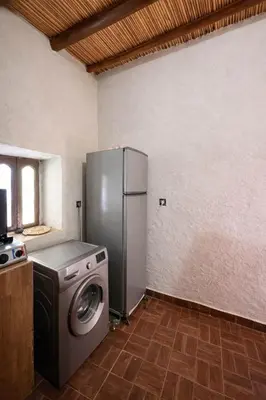 a kitchen with a refrigerator and a washing machine at Casa Mona in Merzouga