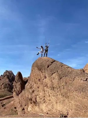 two people jumping on top of a rock at Maison D'hôte La Vallée Des Figues in Tamellalt