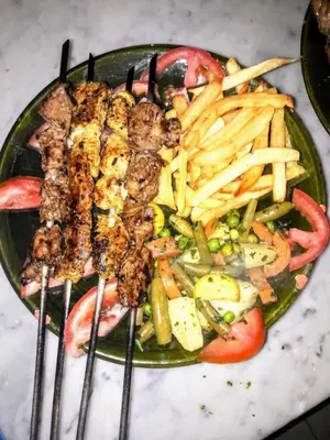 a plate of food with meat and french fries at Dromadaire Gourmand in Zagora