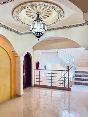 a large room with a chandelier and a staircase at Dromadaire Gourmand in Zagora