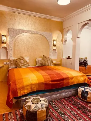 a bedroom with a large bed with a colorful bedspread at Auberge Tissadrine in Akhendachou nʼAït Ouffi