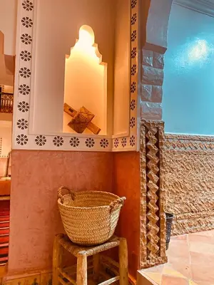 a basket on a stool next to a wall with a mirror at Auberge Tissadrine in Akhendachou nʼAït Ouffi