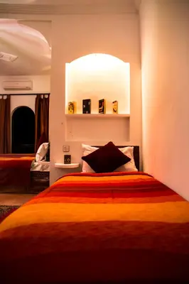 a bedroom with a bed with an orange blanket at Auberge Tissadrine in Akhendachou nʼAït Ouffi