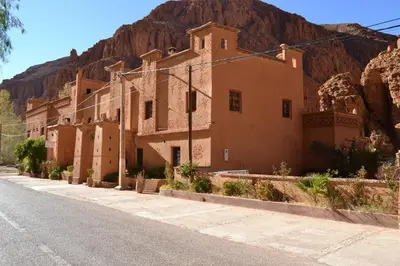 a building on the side of a street with a mountain at Auberge Tissadrine in Akhendachou nʼAït Ouffi