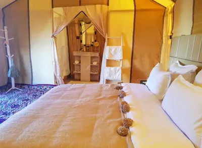 a bedroom with a large bed with stuffed animals on it at Night Luxury Dunes Camp in Merzouga