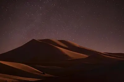 a starry night in the desert with a sand dune at Night Luxury Dunes Camp in Merzouga