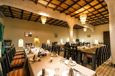 a large dining room with tables and chairs and candles at Ksar Bicha in Merzouga