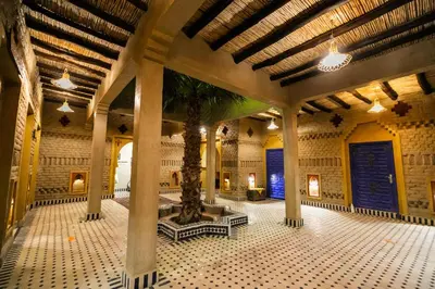 a room with a palm tree in the middle of a building at Ksar Bicha in Merzouga