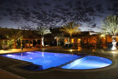 a large swimming pool in a yard at night at Ksar Bicha in Merzouga