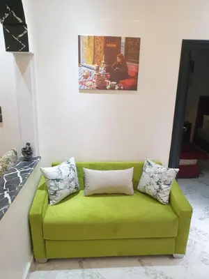 a green couch with two pillows on a wall at White House in Azrou