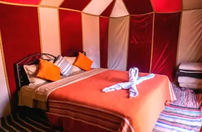 a room with a bed in a tent at Desert Romantic Camp in Merzouga