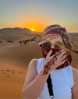 a woman in the desert holding a stick in her mouth at Desert Romantic Camp in Merzouga