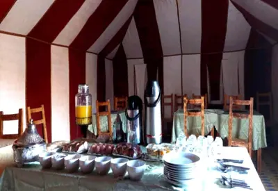 a table with plates and cups on top of it at Desert Romantic Camp in Merzouga