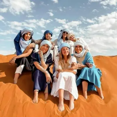 a group of women sitting in the desert at Desert Romantic Camp in Merzouga