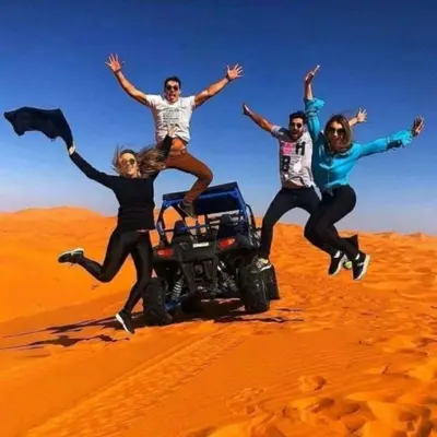 a group of four people jumping in the desert at Desert Romantic Camp in Merzouga