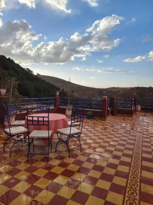 a patio with a table and chairs on a checkered floor at Ourika lodge the healing place in Tafza