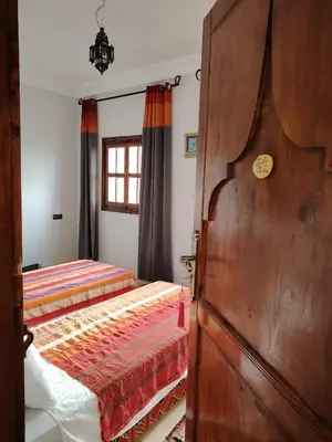 a bedroom with two beds and a wooden door at Ourika lodge the healing place in Tafza
