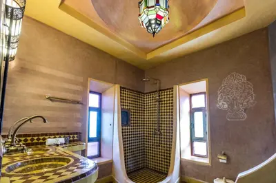 a large bathroom with a shower and a sink at Riad Madu in Merzouga