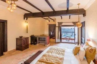 a living room with a couch and a fireplace at Riad Madu in Merzouga