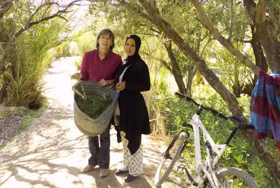 two women standing next to a bike on a trail at Auberge Migusta in Skoura