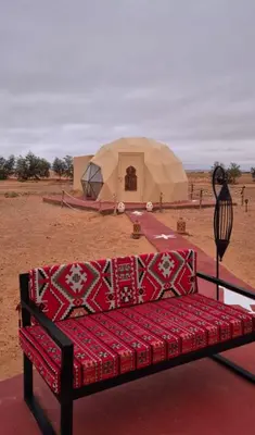 a couch sitting in front of a tent in the desert at Tatooine Stars Camp in Merzouga