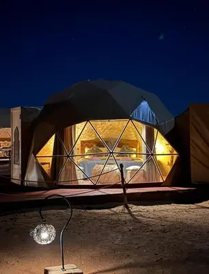 a tent with a light inside of it at night at Tatooine Stars Camp in Merzouga