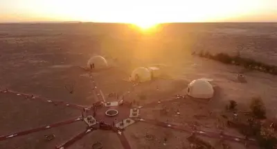 an aerial view of tents in a field at sunset at Tatooine Stars Camp in Merzouga