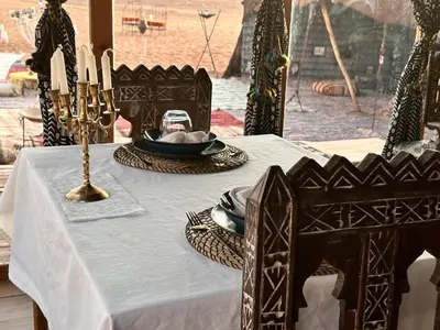 a table with a blue table cloth and candles on it at Sunrise Sahara Camp in Merzouga