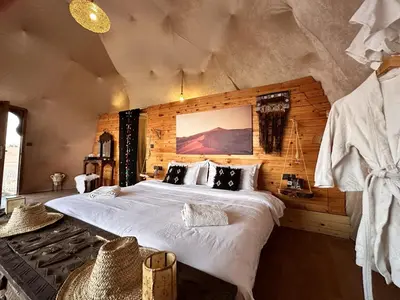 a bedroom with a large bed in a room at Sunrise Sahara Camp in Merzouga