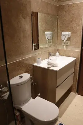 a bathroom with a toilet and a sink and a mirror at Luxury Appartement Noor in Fès