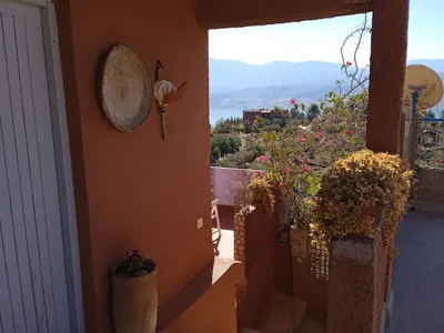 a balcony with a view of a hill with flowers at Abla room in Azilal