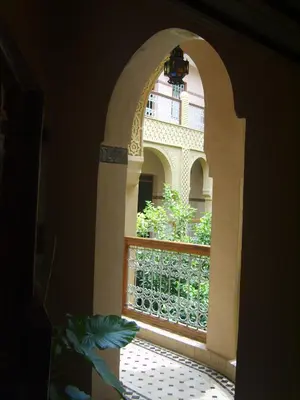 an arched window with a view of a balcony at Riad Les Chrifis Navette Aéroport 24 sur 24 in Fès