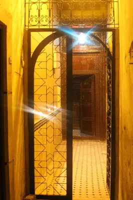 a door with a light shining into a room at Riad Les Chrifis Navette Aéroport 24 sur 24 in Fès