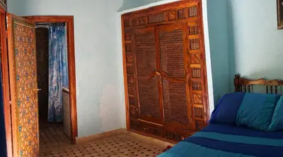 a bedroom with a wooden door and a bed at Riad Les Chrifis Navette Aéroport 24 sur 24 in Fès