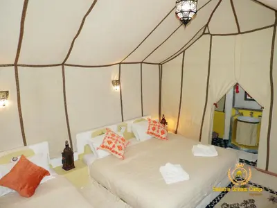 a bedroom with two beds in a tent at Sleep In Luxury Tent In Desert in Merzouga