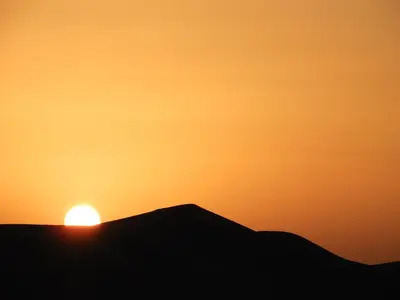 a silhouette of a sunset on a hill at Sleep In Luxury Tent In Desert in Merzouga