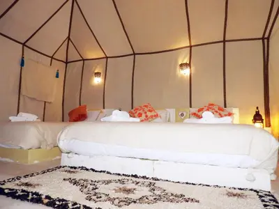 a bedroom with a white bed with a canopy at Sleep In Luxury Tent In Desert in Merzouga