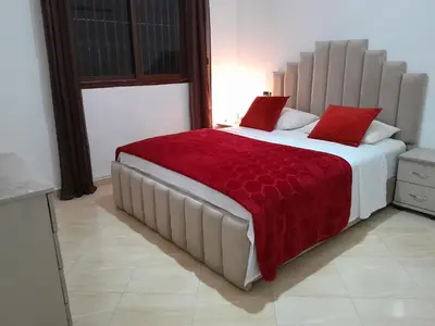 a bedroom with a large bed with red pillows at Welcome Home in Beni Mellal