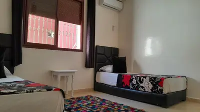 a bedroom with two beds and a window at Welcome Home in Beni Mellal