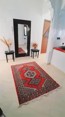 a red rug on a floor in a room with a mirror at Welcome Home in Beni Mellal