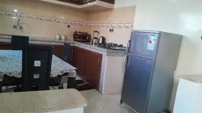 a kitchen with a stainless steel refrigerator and a table at Welcome Home in Beni Mellal