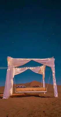a bed in a tent in the desert at Morocco Luxury Camp - Merzouga Desert Retreat in Merzouga