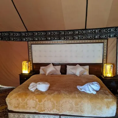 a bedroom with a bed with two towels on it at Morocco Luxury Camp - Merzouga Desert Retreat in Merzouga