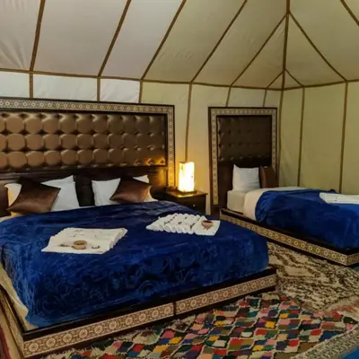 a bedroom with two beds in a tent at Morocco Luxury Camp - Merzouga Desert Retreat in Merzouga