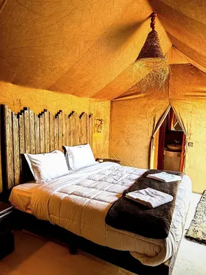 a bedroom with a bed in a tent at Morocco Luxury Camp - Merzouga Desert Retreat in Merzouga
