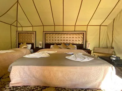 a bedroom with two beds in a tent at Morocco Luxury Camp - Merzouga Desert Retreat in Merzouga