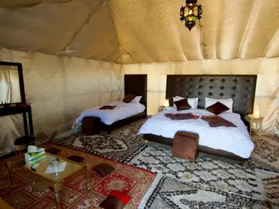 a bedroom with two beds in a tent at Morocco Luxury Camp - Merzouga Desert Retreat in Merzouga