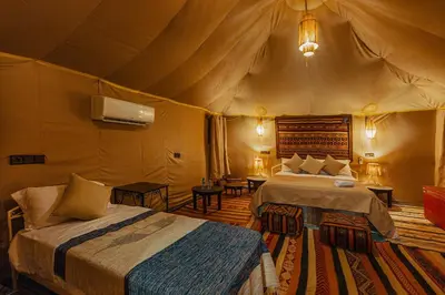 a bedroom with two beds in a tent at Paradis Du Sahara in Merzouga