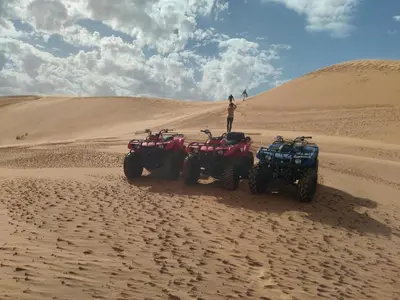 two atvs and a man standing in the desert at Chigaga Desert Camp in Mhamid